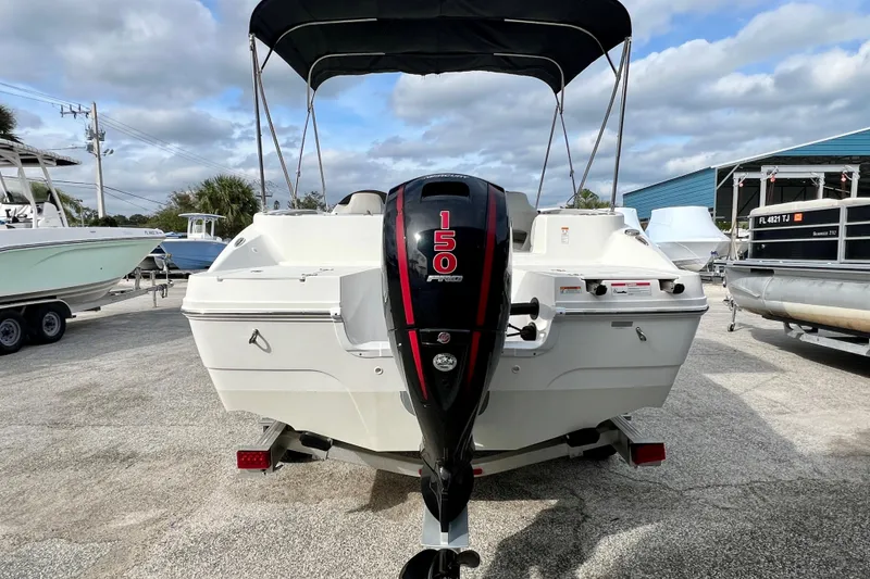 Slide: The Image of 2024 Hurricane Sundeck Sport 218 OB boat with 150 horsepower engine, parked outdoors. - 7