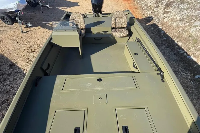 Slide: The Image of 2026 Lowe Roughneck 2070 boat with camouflage seats, parked on gravel. - 13