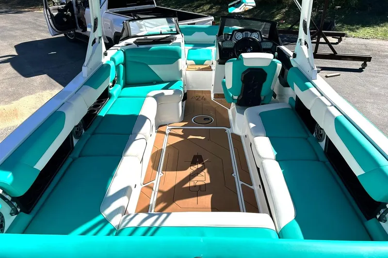 Slide: The Image of 2021 Axis A24 boat interior with teal and white seating, modern dashboard, and spacious layout. - 3