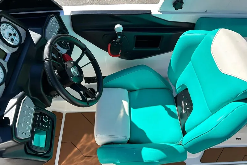 Slide: The Image of 2021 Axis A24 boat interior with teal and white captain's seat and dashboard. - 41
