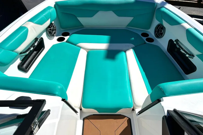 Slide: The Image of 2021 Axis A24 boat interior with teal and white seating, cup holders, and speakers. - 7