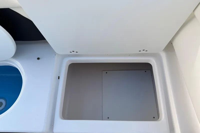 Slide: The Image of Storage compartment on a 2022 Tidewater 220 LXF boat, featuring a clean, white interior. - 18