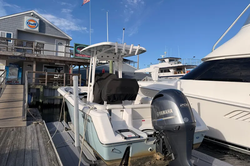 Slide: The Image of 2022 Tidewater 220 LXF boat docked, showcasing spacious seating and sleek design. - 3