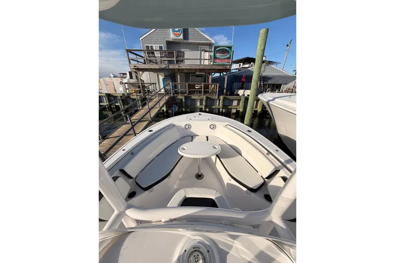 Slide: The Image of 2022 Tidewater 220 LXF boat docked with outboard motor, calm water, and clear sky. - 5