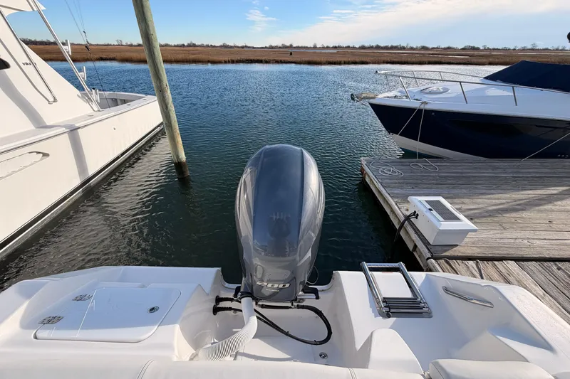 Slide: The Image of 2022 Tidewater 220 LXF boat interior with dual seats and steering wheel by the water. - 6