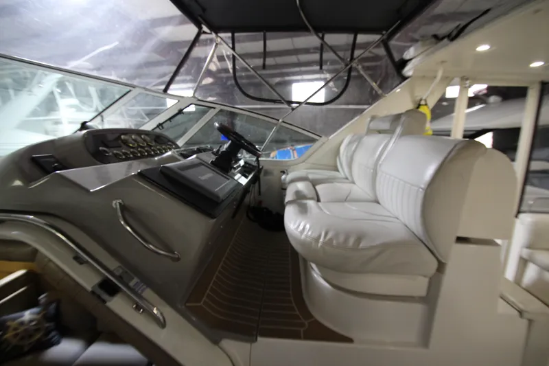 Slide: The Image of 2003 Cruisers Yachts 4450 Express Motoryacht cockpit with white seating and control panel. - 7