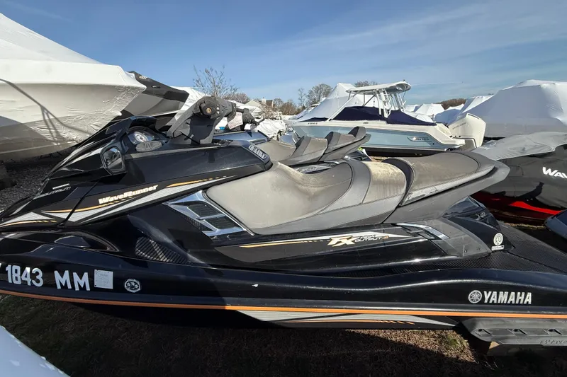 Slide: The Image of 2016 Yamaha WaveRunner FX HO jet ski in storage, surrounded by covered boats. - 4