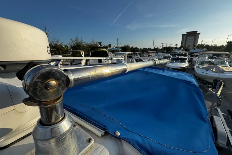 Slide: The Image of 2012 Renegade 32 CC boat with blue cover in marina, surrounded by other boats. - 33