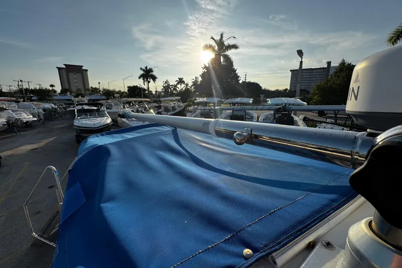 Slide: The Image of 2012 Renegade 32 CC boat with blue cover, parked in marina at sunset. - 35