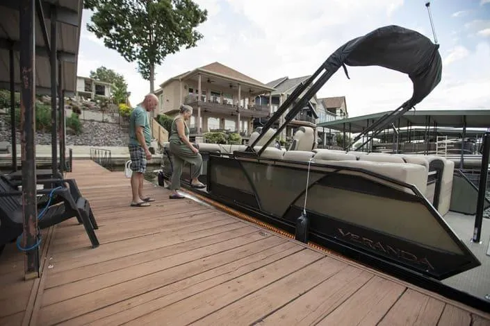 Slide: The Image of Couple boarding 2026 Veranda RELAX VR235VLI pontoon boat at a lakeside dock. - 11