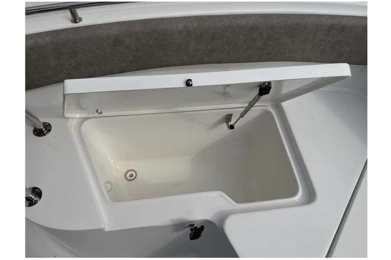 Slide: The Image of 2025 Sea Hunt Ultra 219 boat dashboard with compass and logo, parked in marina. - 28