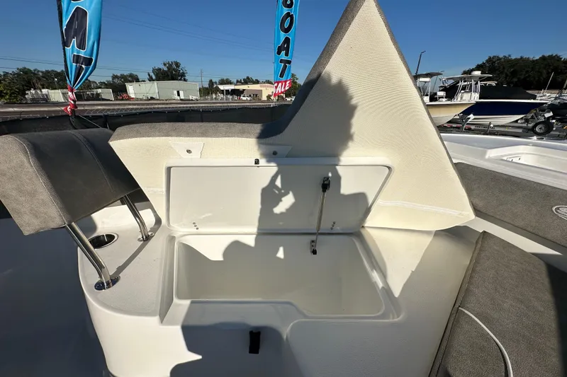 Slide: The Image of 2025 Sea Hunt Ultra 219 boat storage compartment with open lid, showcasing interior space. - 46
