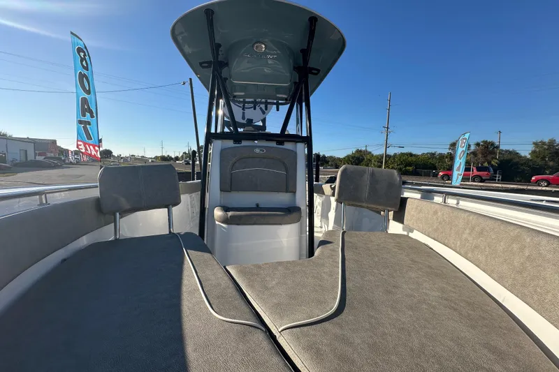 Slide: The Image of 2025 Sea Hunt Ultra 219 boat interior with seating and console, displayed outdoors. - 49