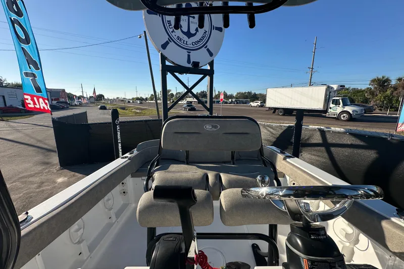 Slide: The Image of 2025 Sea Hunt Ultra 219 boat interior with steering wheel, parked outdoors. - 52