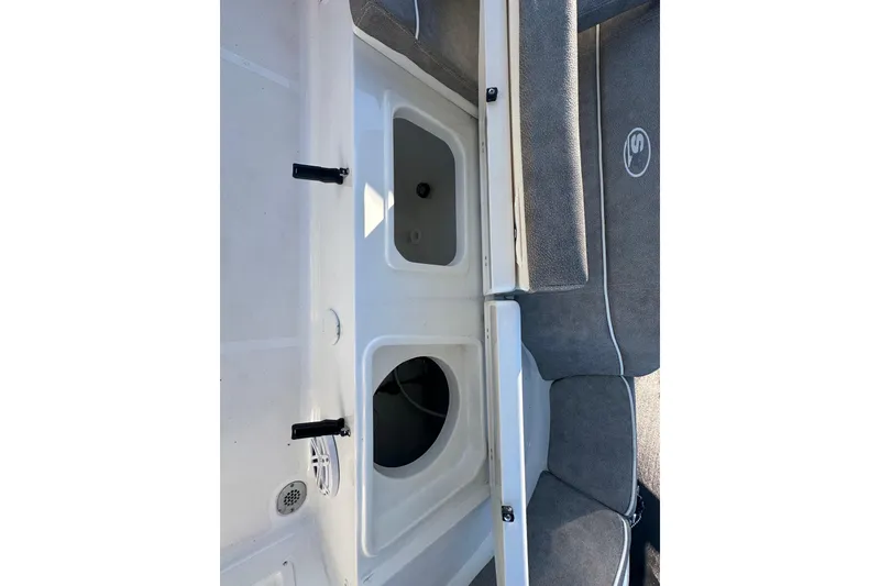 Slide: The Image of 2025 Sea Hunt Ultra 219 boat interior with storage compartments and cushioned seating. - 57