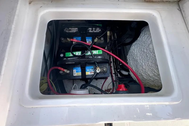 Slide: The Image of Battery compartment of 2025 Sea Hunt Ultra 219 boat, showing wiring and connections. - 58