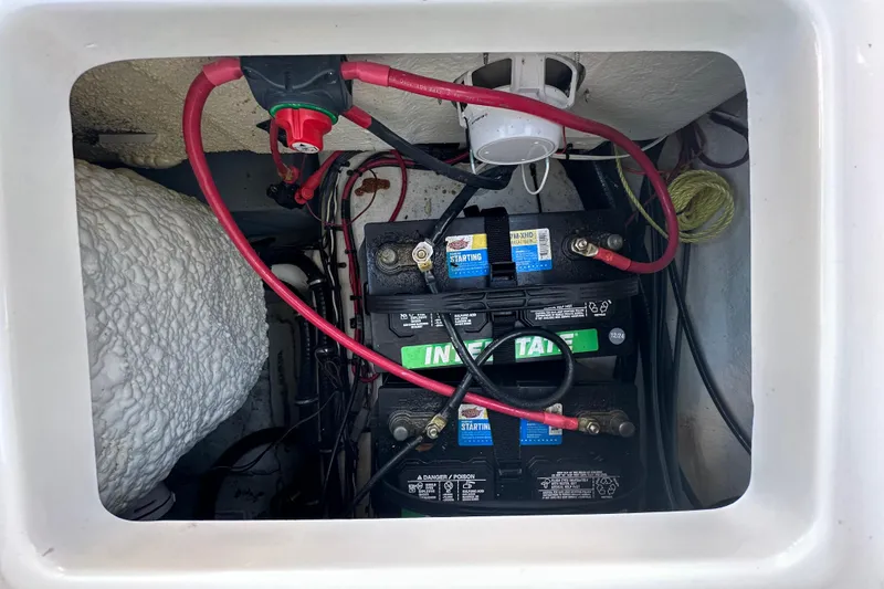 Slide: The Image of Battery compartment of 2025 Sea Hunt Ultra 219 boat with wiring and connections. - 59