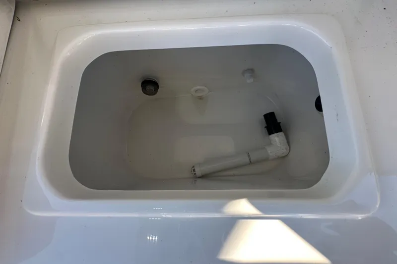 Slide: The Image of Livewell compartment in 2025 Sea Hunt Ultra 219 boat, featuring plumbing and drainage. - 61