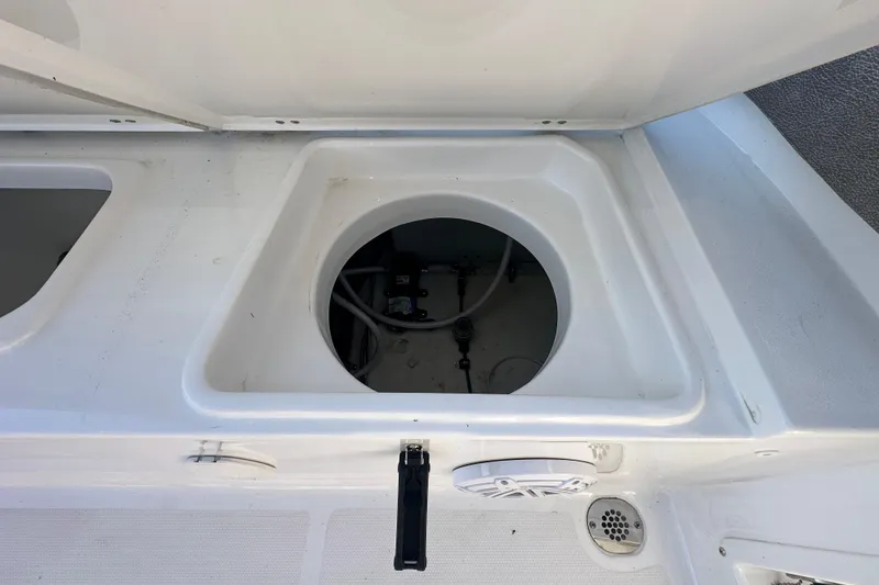 Slide: The Image of 2025 Sea Hunt Ultra 219 boat storage compartment with open hatch and visible wiring. - 62