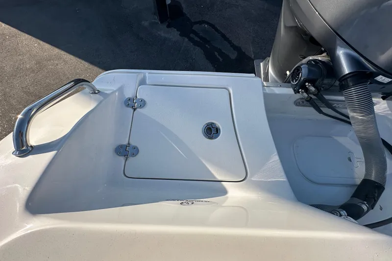 Slide: The Image of 2025 Sea Hunt Ultra 219 boat deck with storage compartment and motor details. - 64