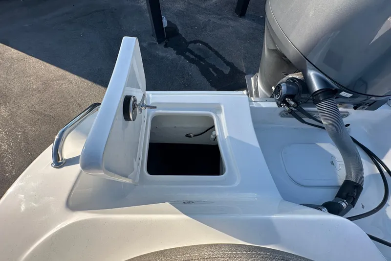 Slide: The Image of 2025 Sea Hunt Ultra 219 boat with open storage compartment and visible engine components. - 65