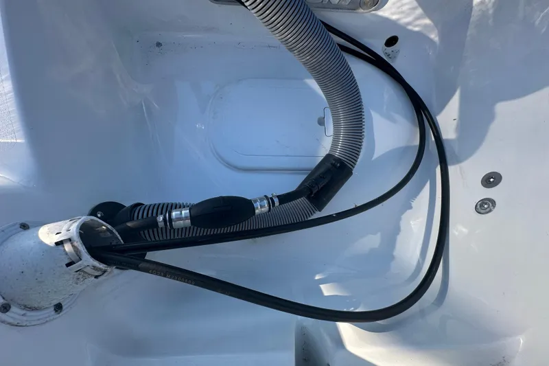 Slide: The Image of 2025 Sea Hunt Ultra 219 boat interior with hoses and fittings. - 67