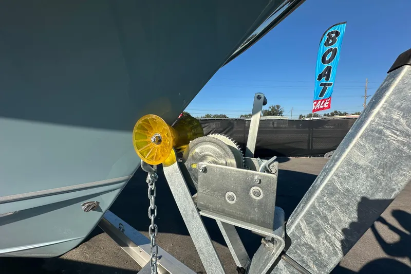 Slide: The Image of 2025 Sea Hunt Ultra 219 boat on trailer at sale event, blue sky background. - 69