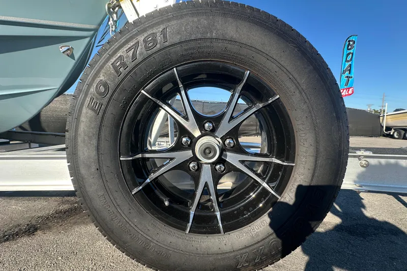 Slide: The Image of Close-up of a Sea Hunt Ultra 219 trailer tire, showcasing black alloy wheel design. - 71