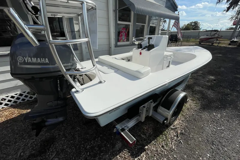 Slide: The Image of 2026 Delta Boatworks Delta D18 with Yamaha engine, parked on a trailer outside a building. - 2