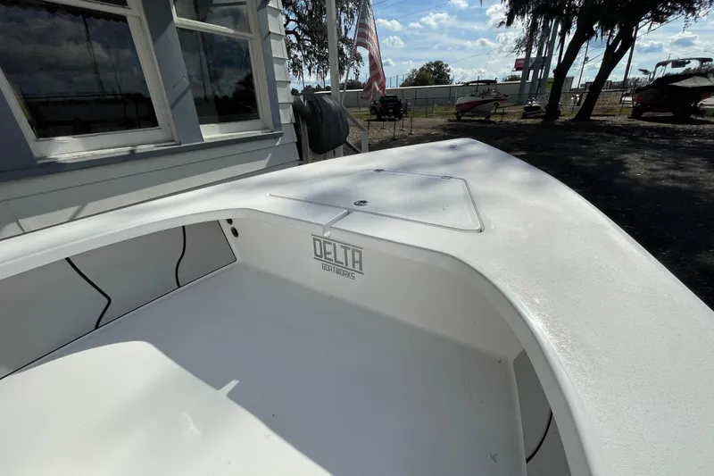 Slide: The Image of 2026 Delta Boatworks Delta D18, white interior, docked near a building under a blue sky. - 6