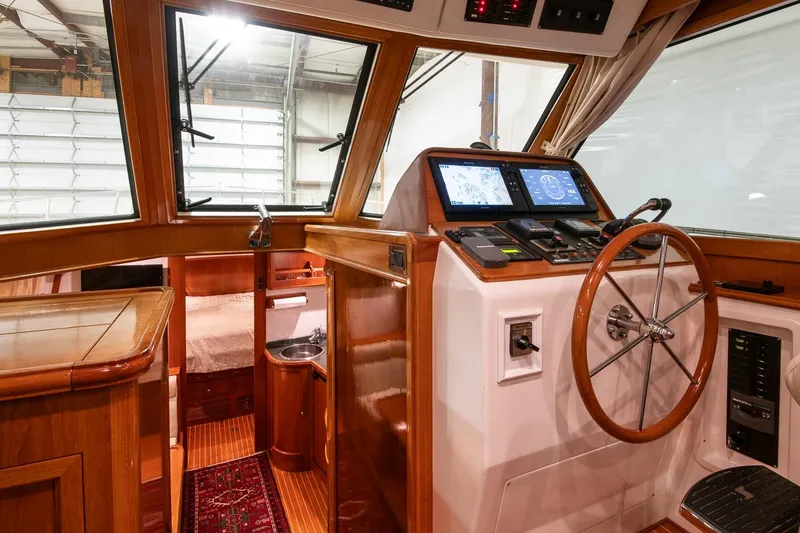Slide: The Image of 2007 Grand Banks 39 Eastbay SX yacht interior with wooden helm, navigation screens, and cozy cabin. - 25
