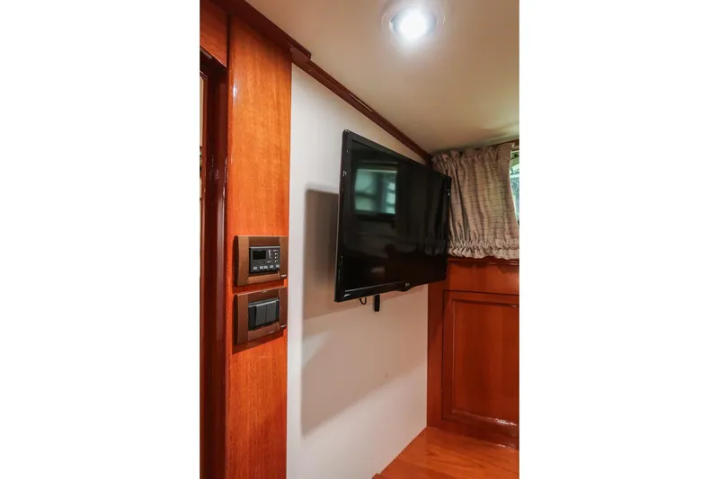 Slide: The Image of 2007 Grand Banks 39 Eastbay SX interior with wall-mounted TV and wooden paneling. - 35