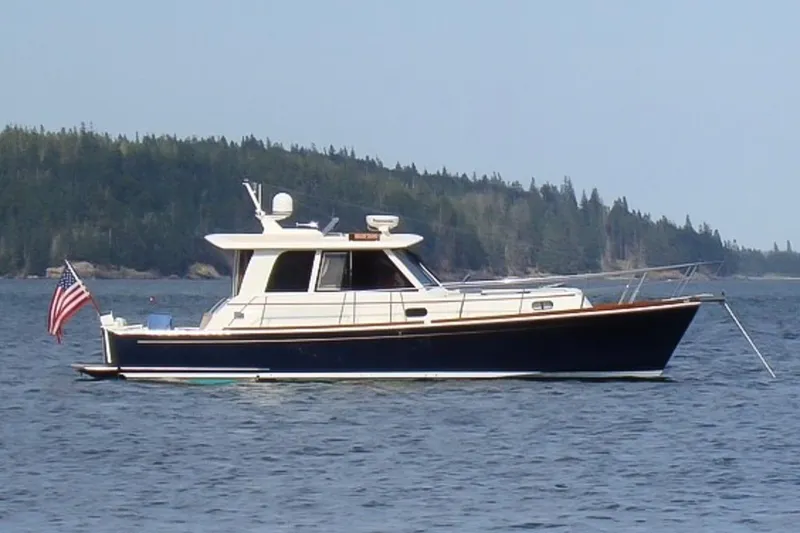 Slide: The Image of 2007 Grand Banks 39 Eastbay SX yacht on calm water with forested shoreline. - 45