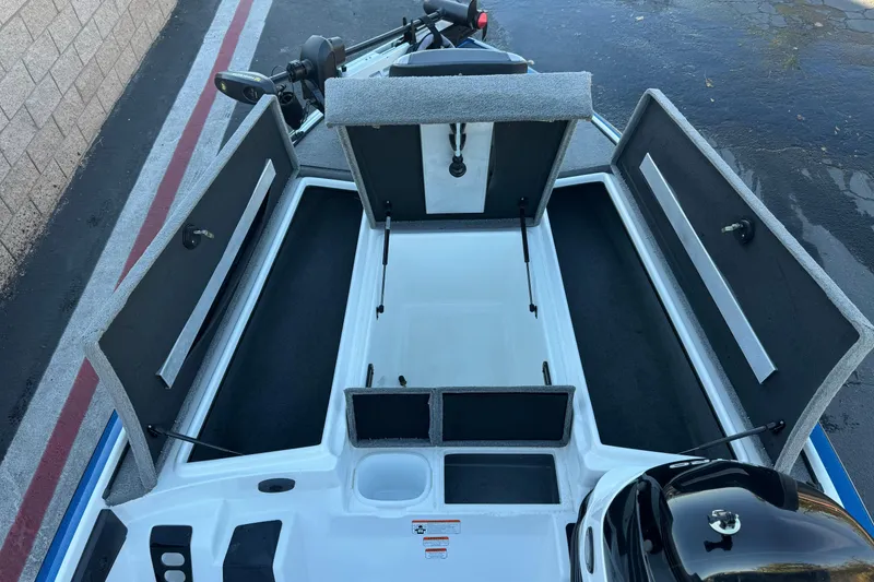 Slide: The Image of 2015 Nitro Z-7 boat with open storage compartments and motor, parked on pavement. - 15