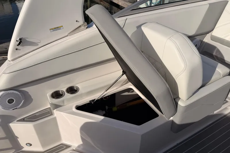 Slide: The Image of 2022 Regal 26 XO boat interior with open storage compartment and cup holders. - 13