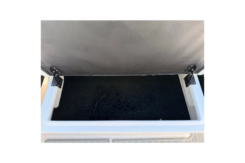 Slide: The Image of Open storage compartment in 2022 Regal 26 XO boat, containing coiled rope. - 14