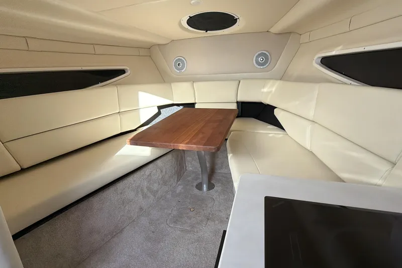 Slide: The Image of 2022 Regal 26 XO boat interior with beige seating and wooden table. - 24