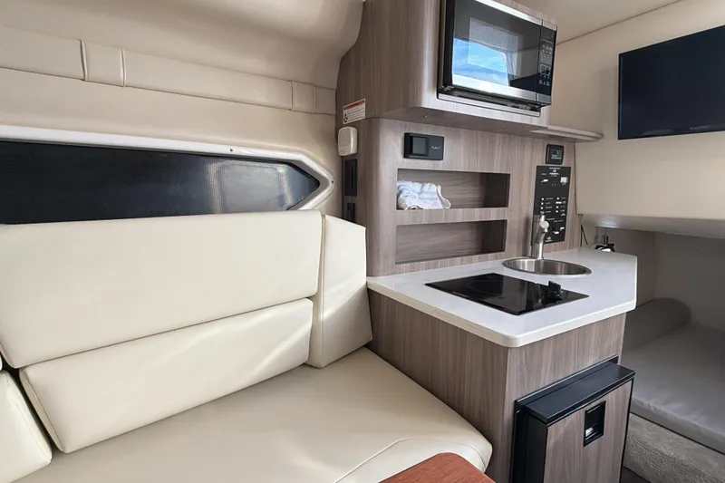 Slide: The Image of 2022 Regal 26 XO boat interior with kitchenette and seating area. - 25