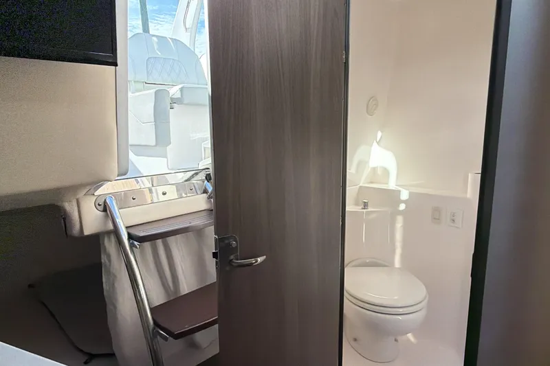 Slide: The Image of 2022 Regal 26 XO boat interior with compact bathroom and seating area. - 29