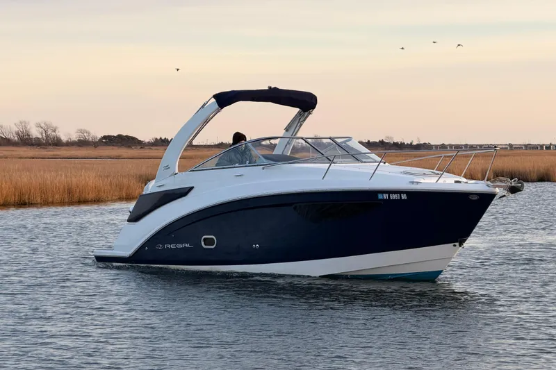 Slide: The Image of 2022 Regal 26 XO boat cruising on calm water at sunset. - 3