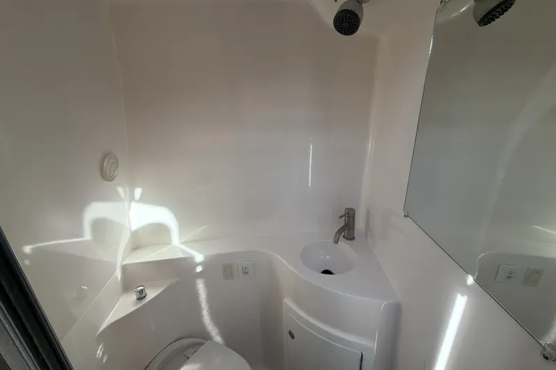 Slide: The Image of 2022 Regal 26 XO boat bathroom with sink, toilet, and mirror. - 31