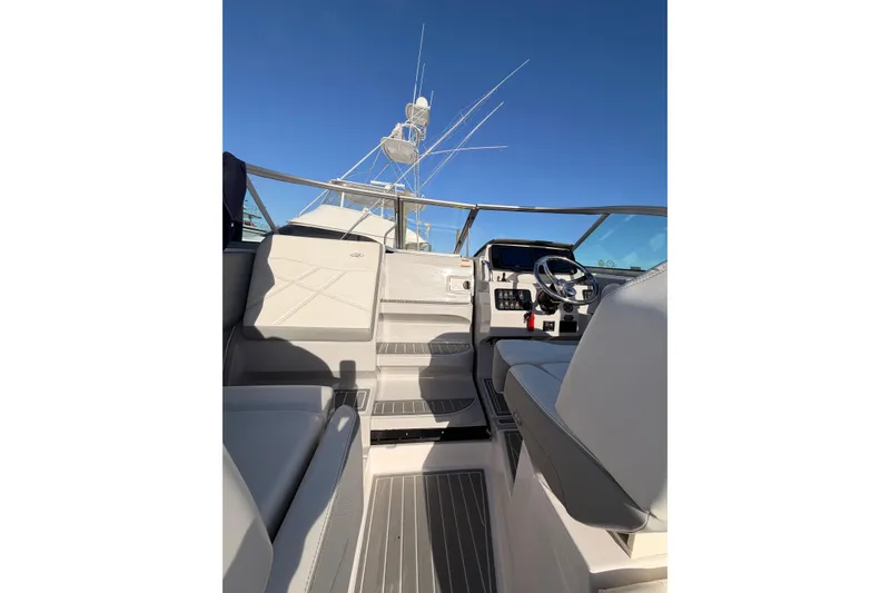 Slide: The Image of 2022 Regal 26 XO boat interior with steering wheel and seating under clear blue sky. - 7