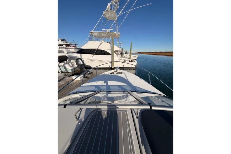 Slide: The Image of 2022 Regal 26 XO boat docked at marina under clear blue sky. - 8
