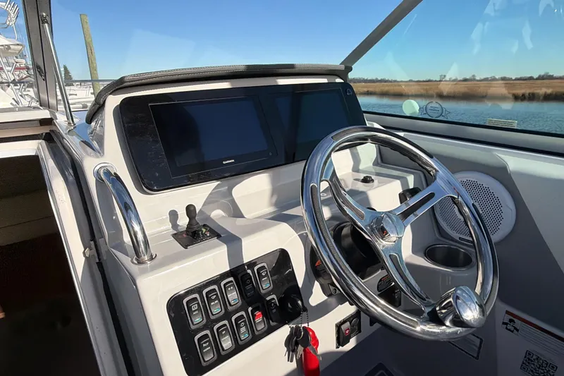 Slide: The Image of 2022 Regal 26 XO boat helm with steering wheel, controls, and navigation display. - 9