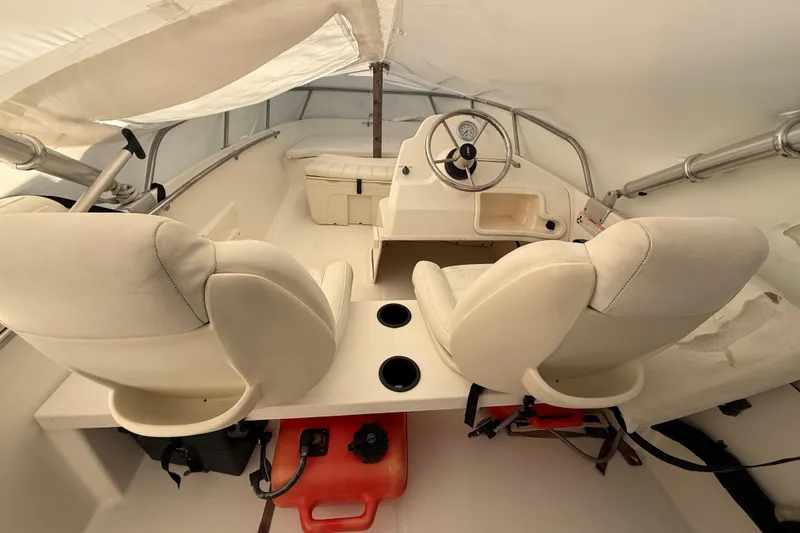Slide: The Image of 2011 Boston Whaler 150 Super Sport interior with dual seats and steering wheel. - 10