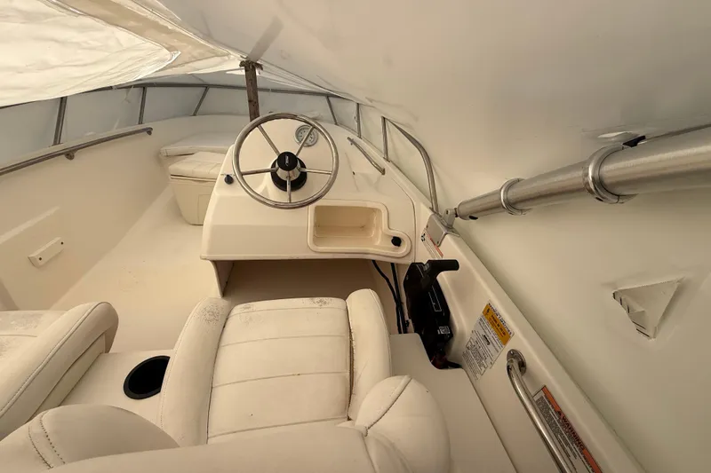 Slide: The Image of Interior of a 2011 Boston Whaler 150 Super Sport boat, featuring steering wheel and seating. - 12
