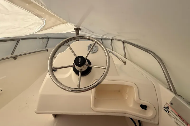 Slide: The Image of Steering console of a 2011 Boston Whaler 150 Super Sport boat. - 13
