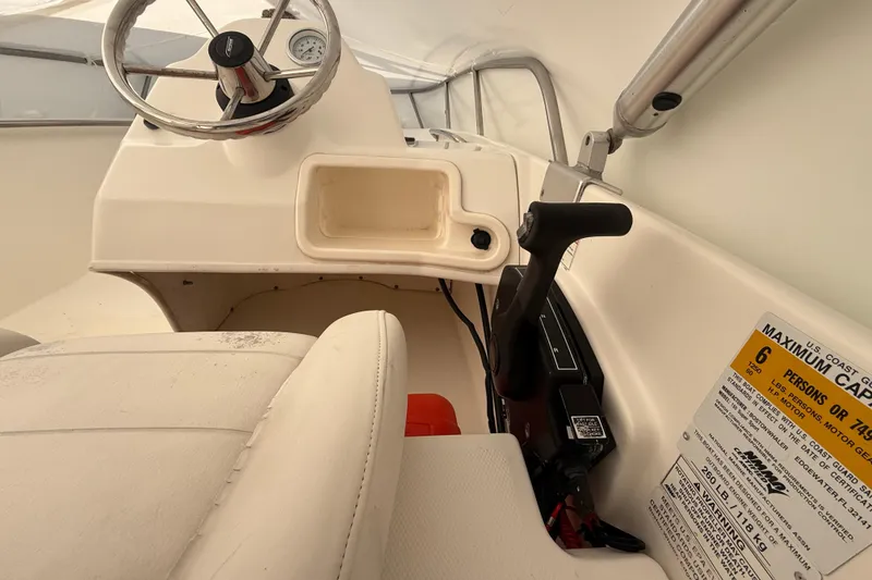 Slide: The Image of Interior of 2011 Boston Whaler 150 Super Sport boat, showing steering wheel and controls. - 14