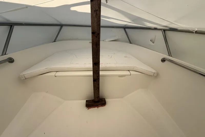 Slide: The Image of 2011 Boston Whaler 150 Super Sport interior with white seating and wooden support. - 16