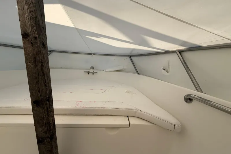 Slide: The Image of 2011 Boston Whaler 150 Super Sport interior with white seating and wooden support beam. - 18